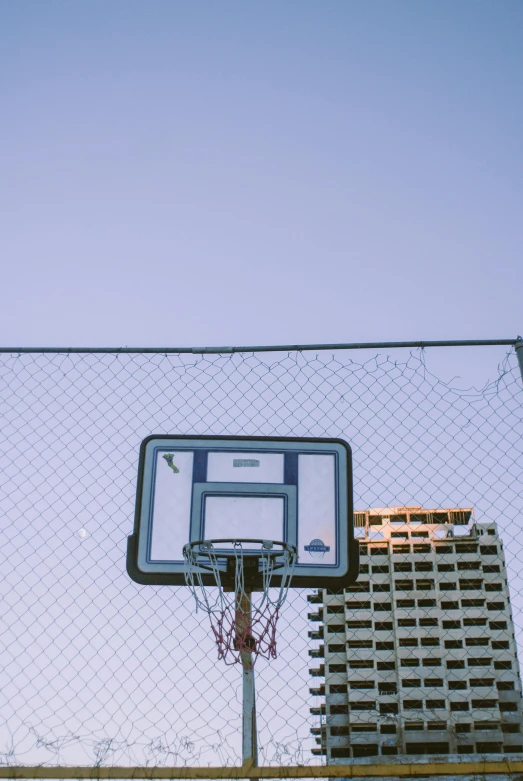 a basketball hoop with building in the background