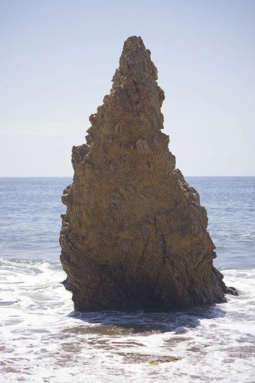 there is a large rock formation on the beach