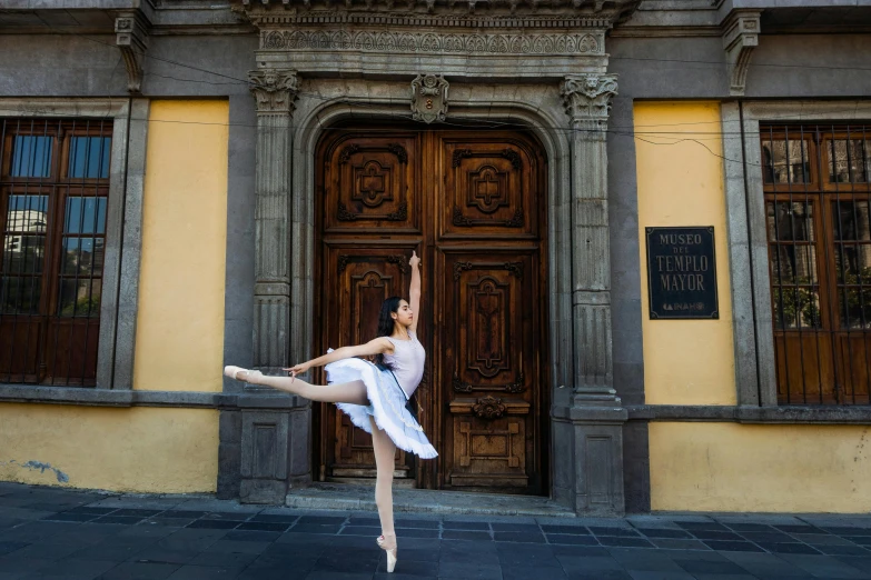 a ballerina posing in front of a building