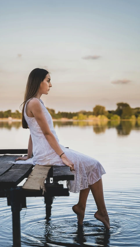 a woman sitting on a bench in the water