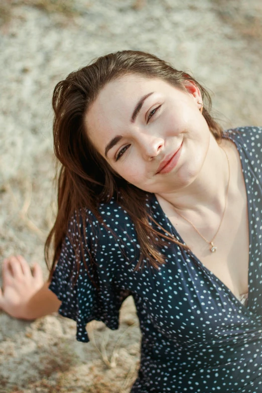 a woman with long hair wearing a blue dress smiling and laughing