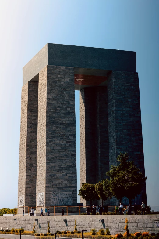 a monument made out of black stones on top of a cement wall