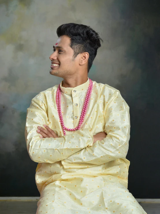 a young man in white is posing with his arms crossed