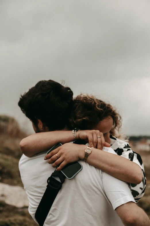 two people are emcing on the field by the beach