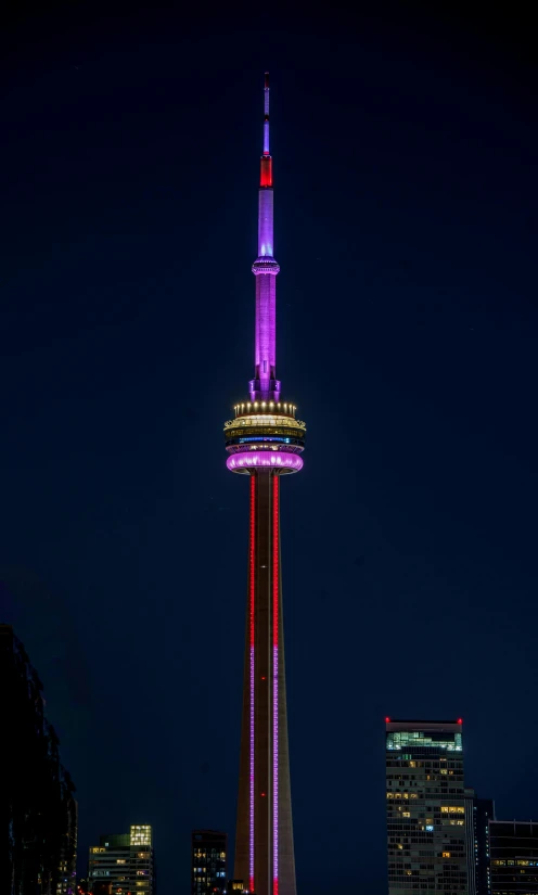 a very tall clock tower lit up with the flag