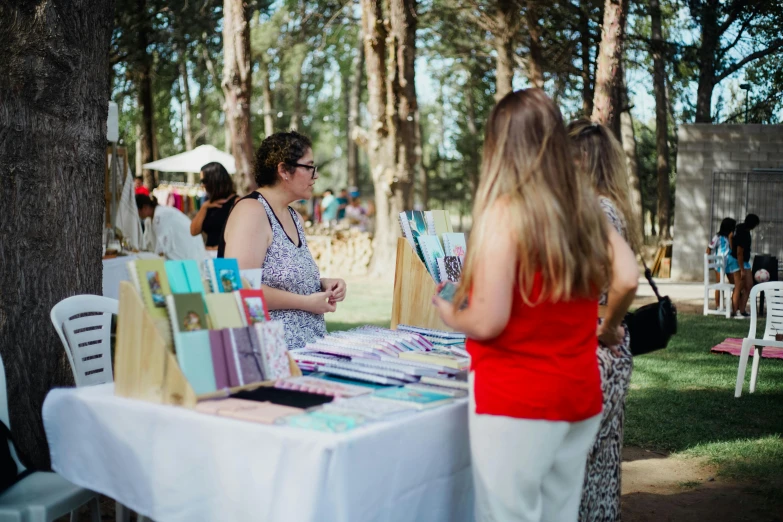 people looking at art work under the trees