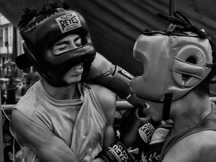 two people wearing boxing gloves and protective gear