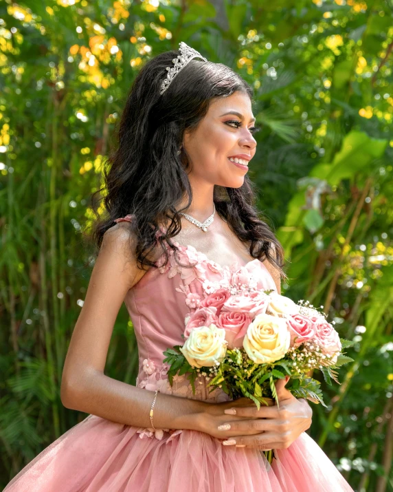 a beautiful woman in pink is holding a bouquet of flowers