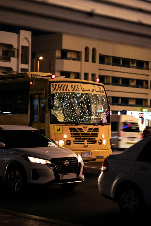 an orange school bus traveling down a street at night