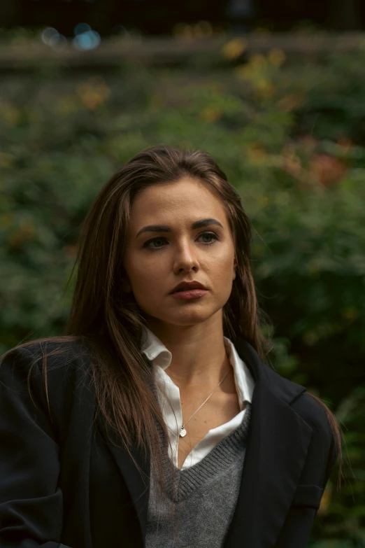 a young woman with dark hair and gray jacket