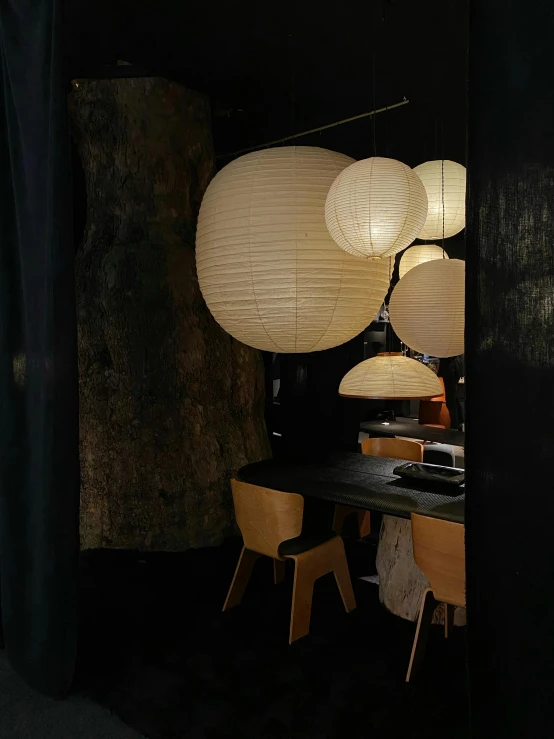 a dimly lit room with three round, cylindrical shaped lamps over a small table