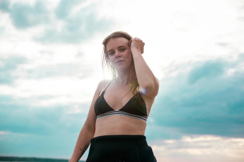 a woman in a bikini stands at the water's edge