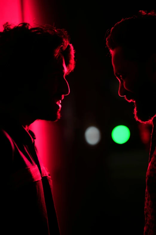 two people standing at night facing each other