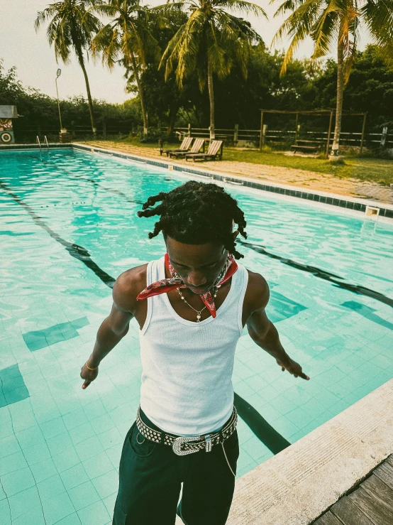 a man on the edge of a swimming pool doing tricks