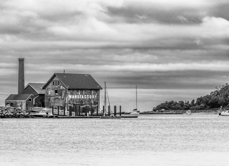 the pier in front of a house and a row of boats are out on the water