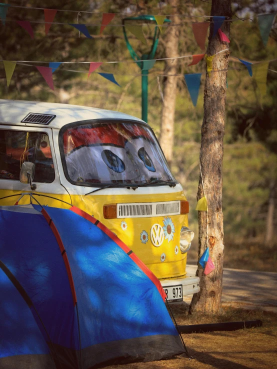 there is an orange, blue and white bus parked next to a tree