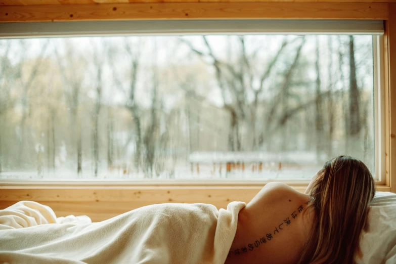 a woman with long hair is laying in bed