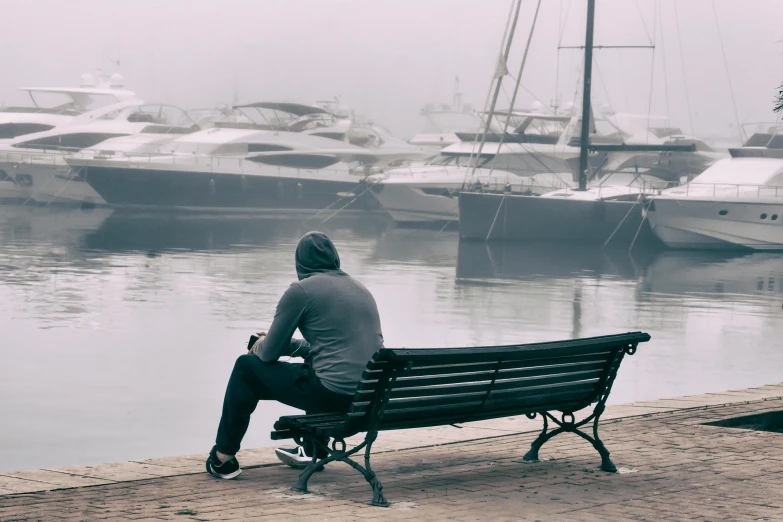 a person sitting on a bench looking out into the water