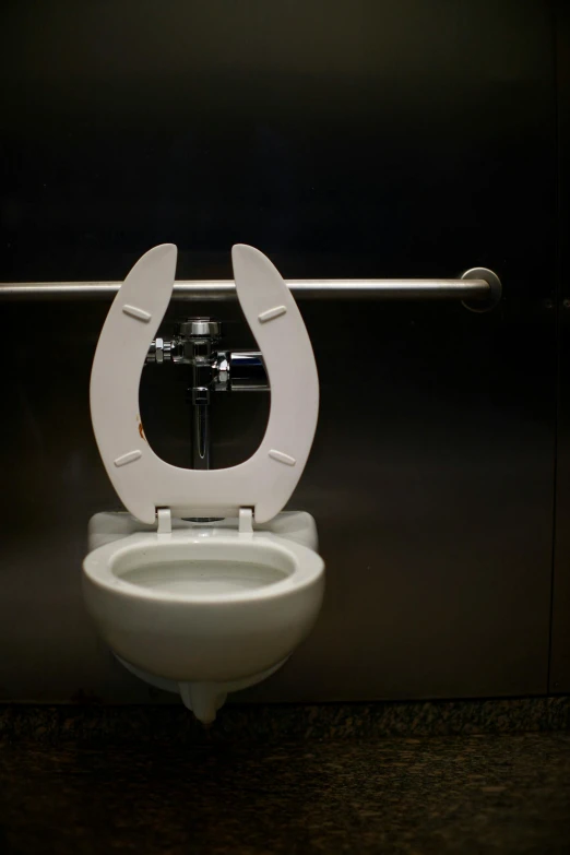 a white toilet with the lid up and a cross at the top of it