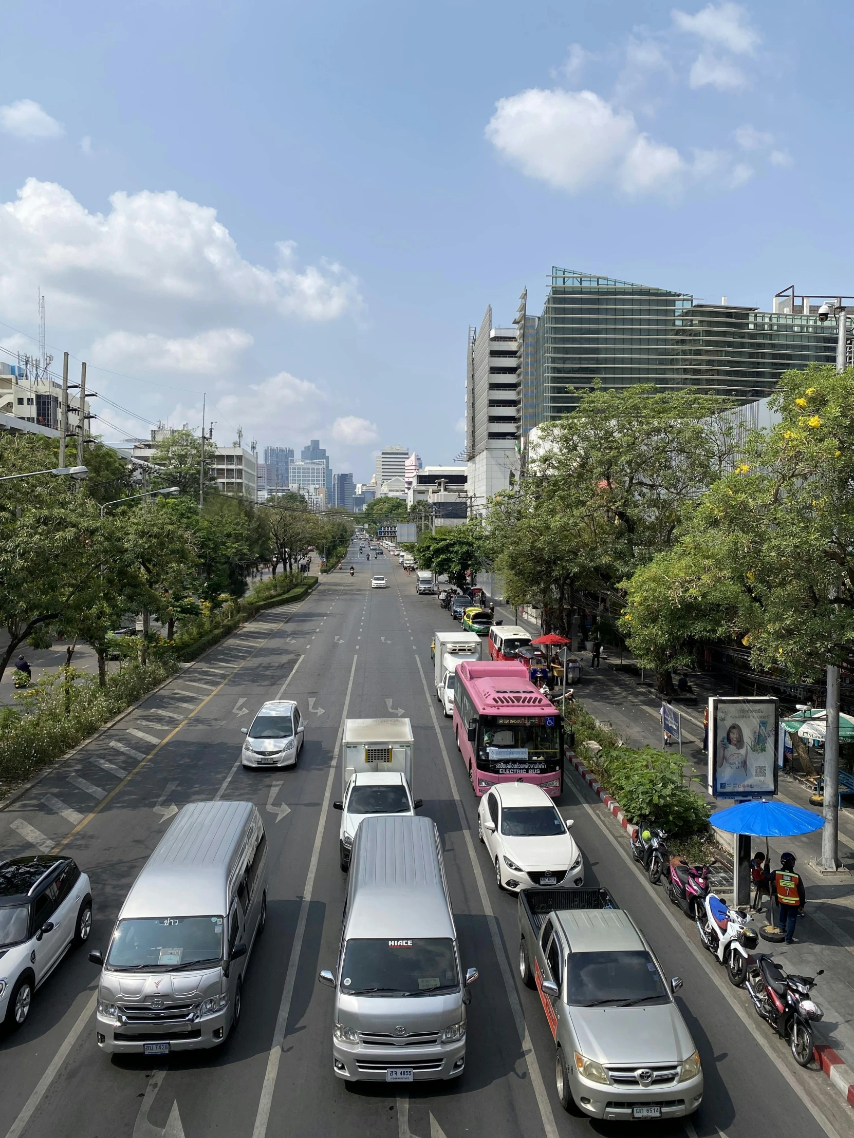 cars driving on a street next to tall buildings