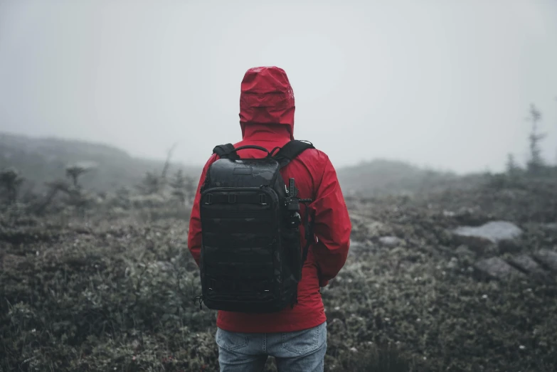 a man with a backpack standing in the fog