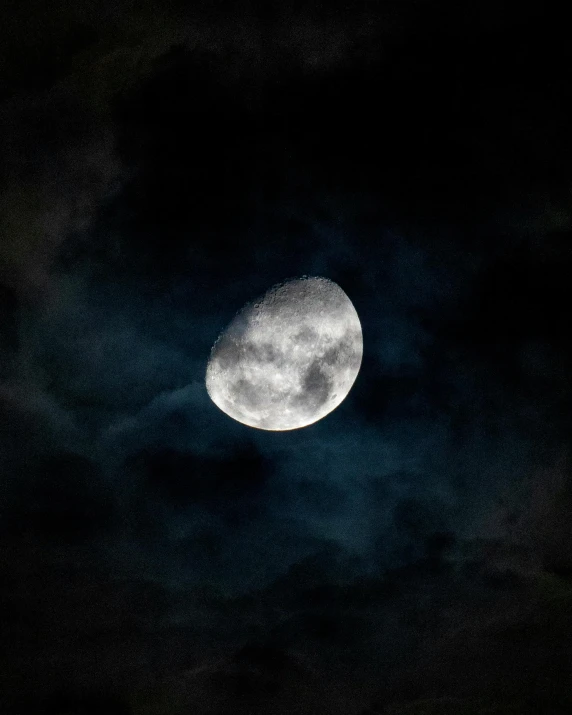 the full moon lit up with a dark sky behind it