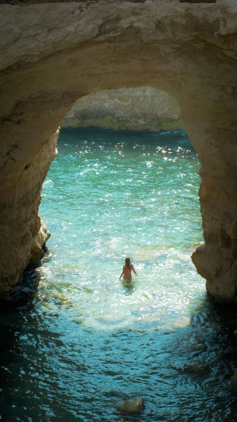 a person in the water near some rocks