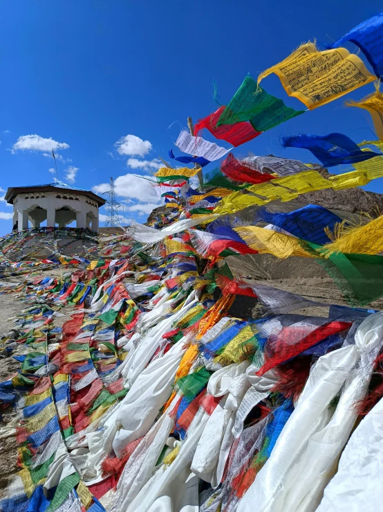 the mountainside with a church covered in colorful buddhist flags