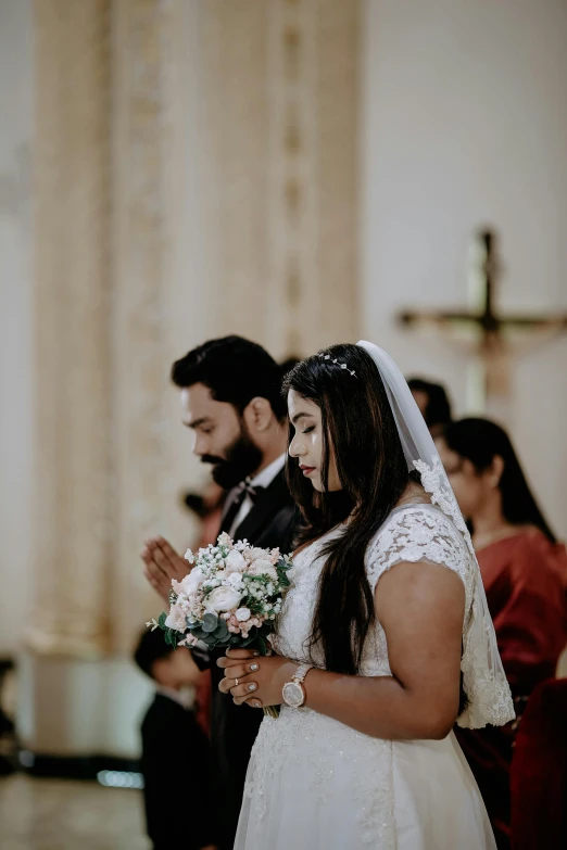 a young woman in white veil and wedding dress standing next to a man