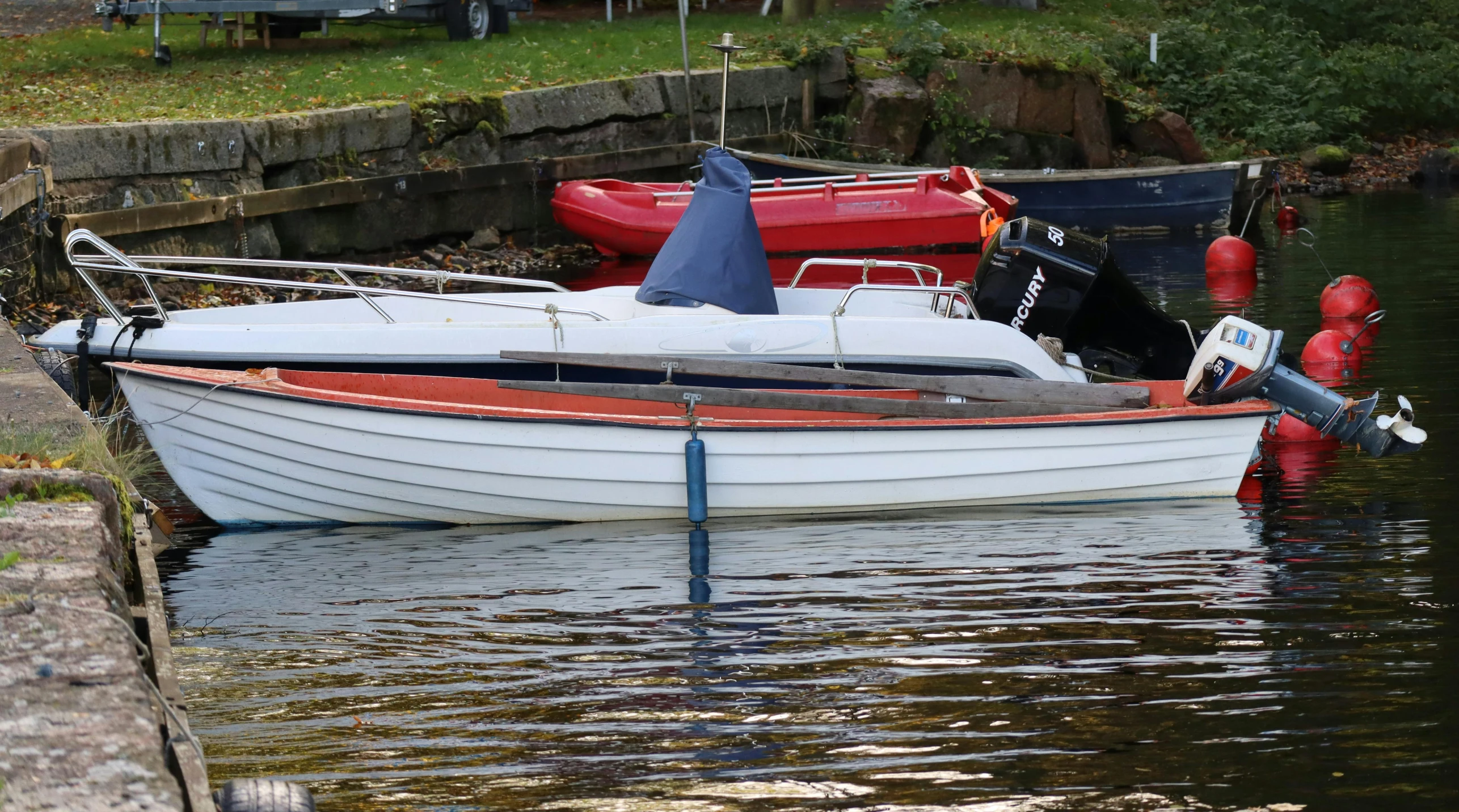 a small white boat in the water at a dock