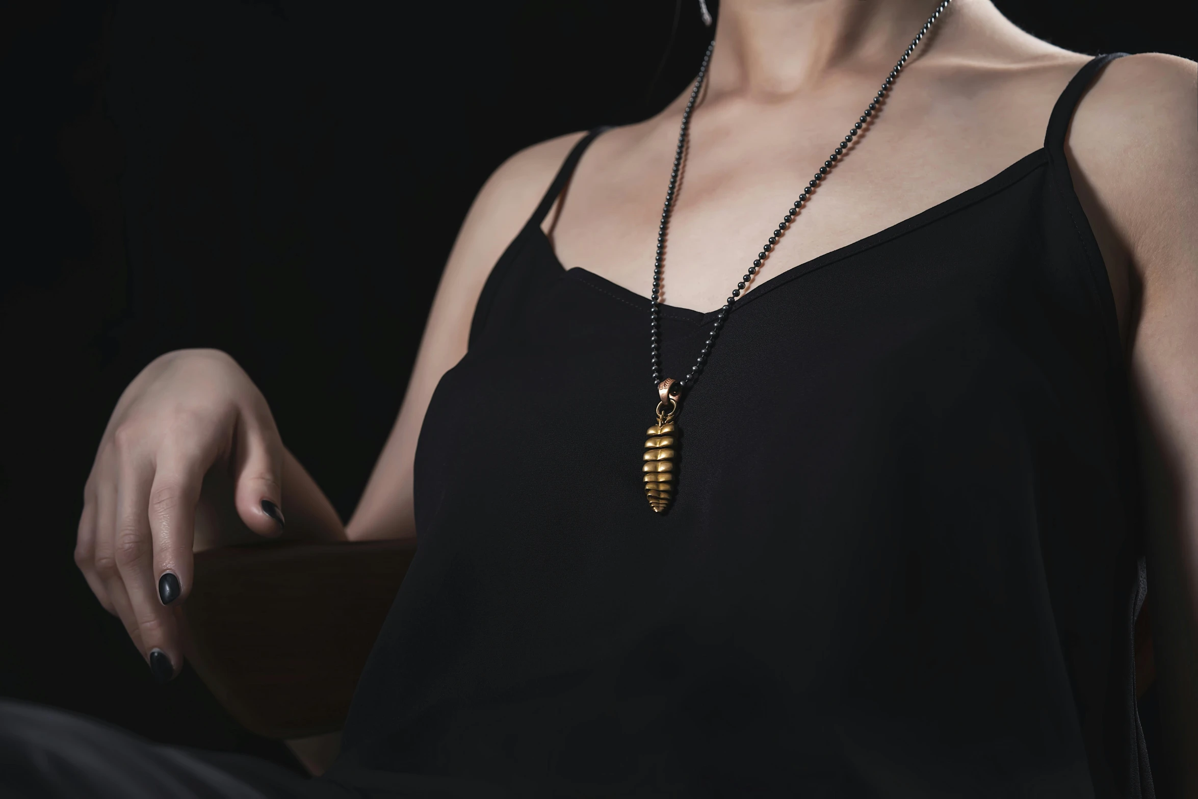 woman holding a wooden vase with a leaf necklace on