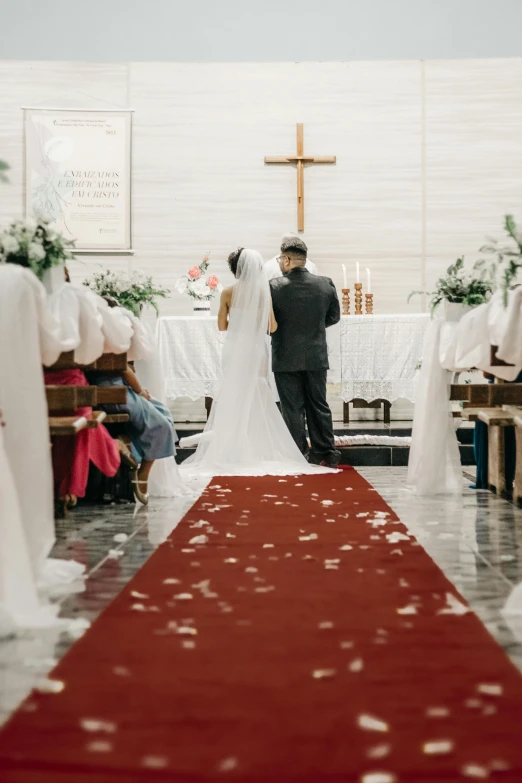 a bride and groom are walking down the aisle