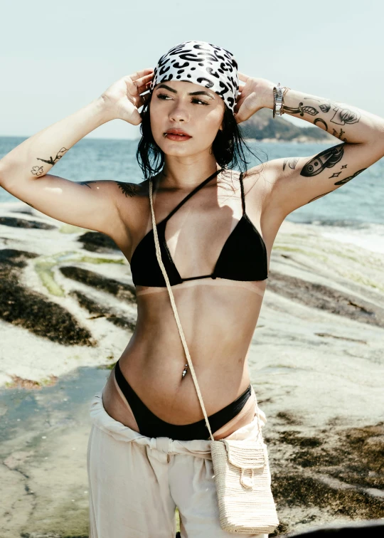 an attractive young woman standing next to the ocean