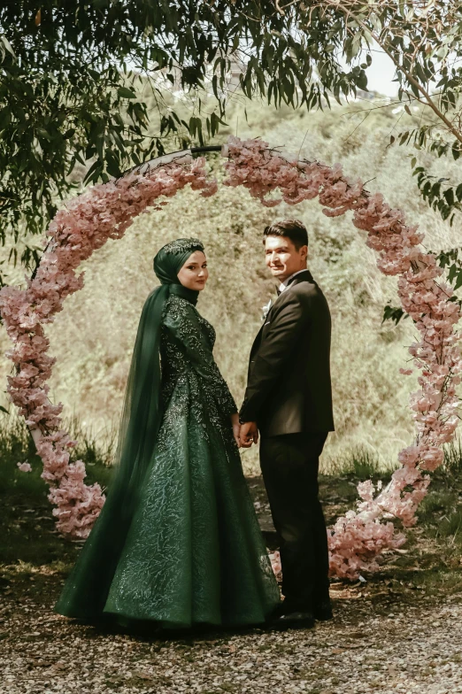 a couple standing under flowers holding hands