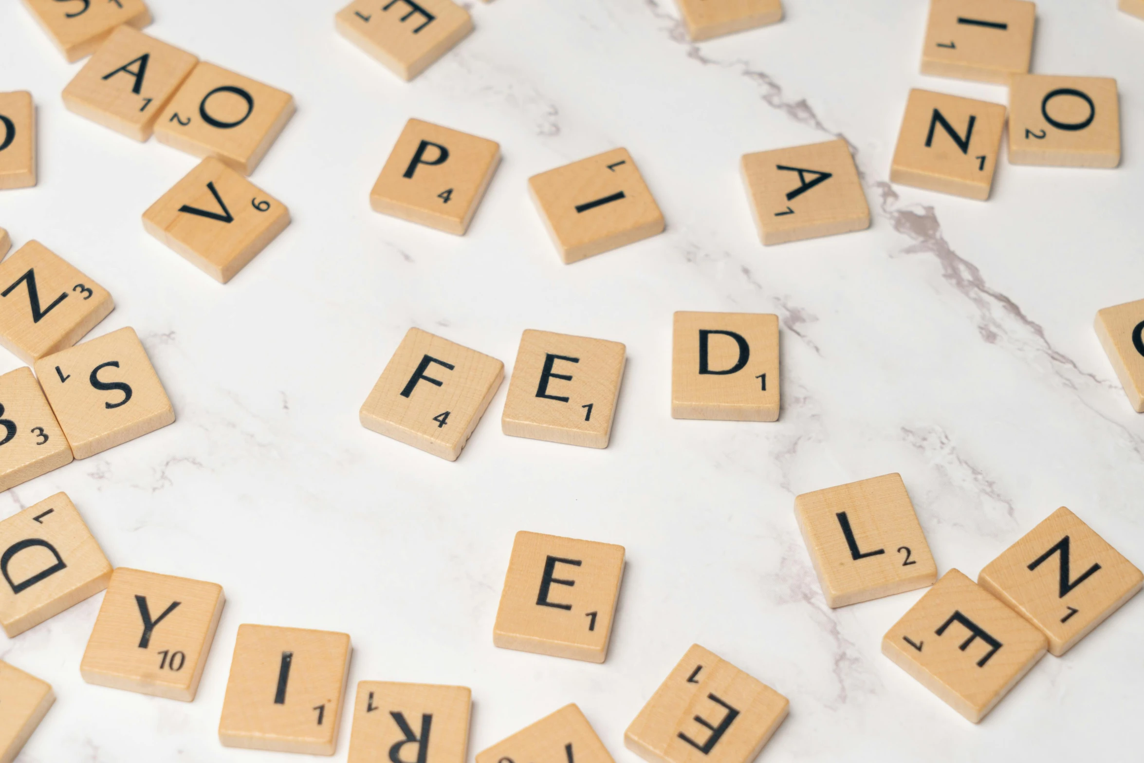 the spelled word on the white background is spelled with small wood blocks