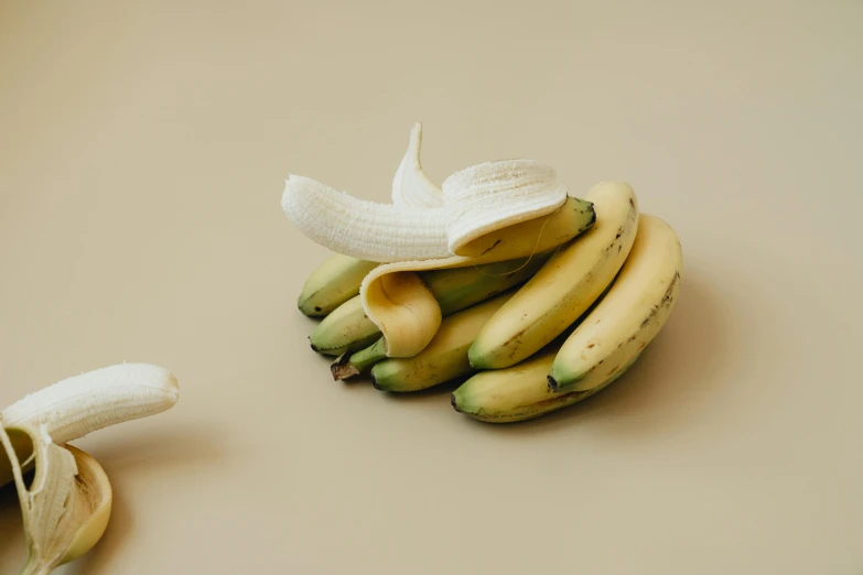 a banana sitting next to a bunch of unripe bananas