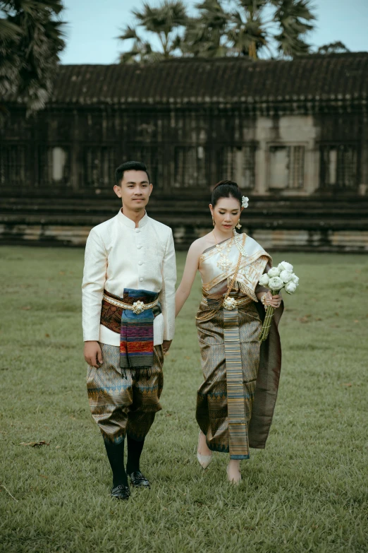 a man and woman are walking in the grass