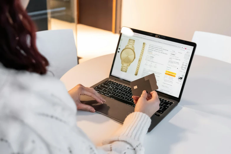 a woman sitting at a table in front of a laptop