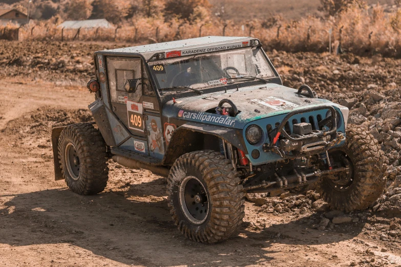 a muddy off road vehicle driving through the dirt