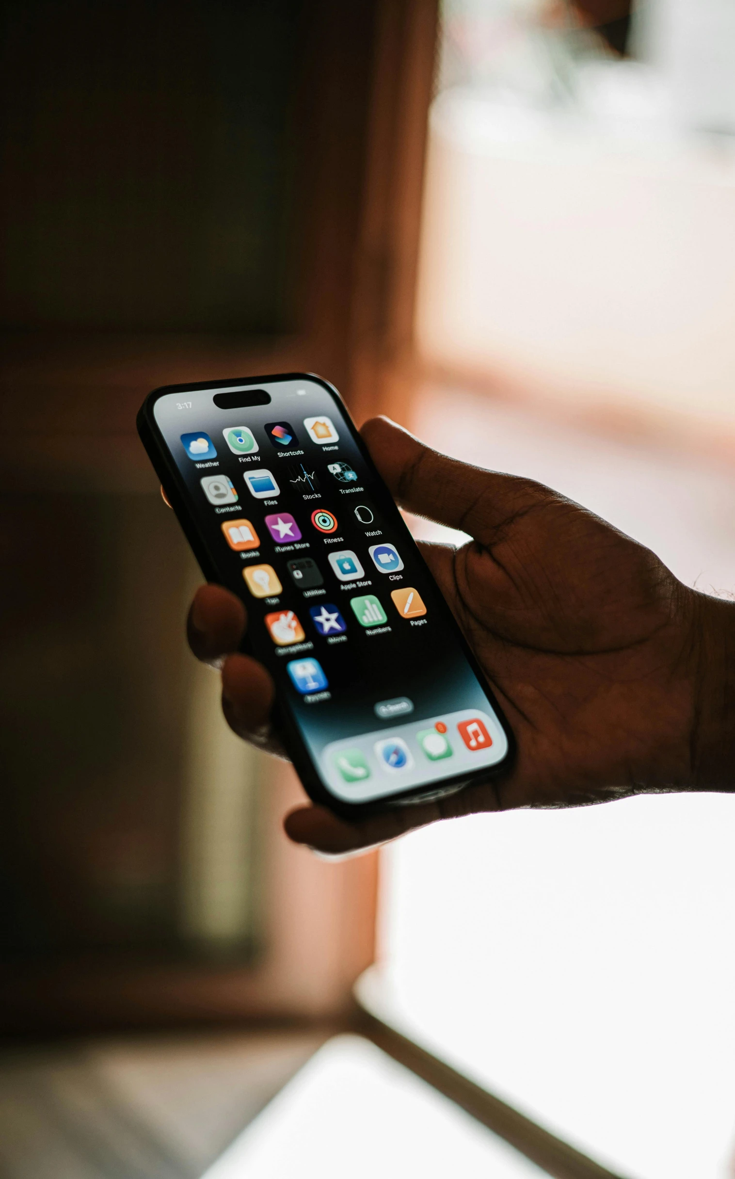 someone holding a cell phone with various apps on the display