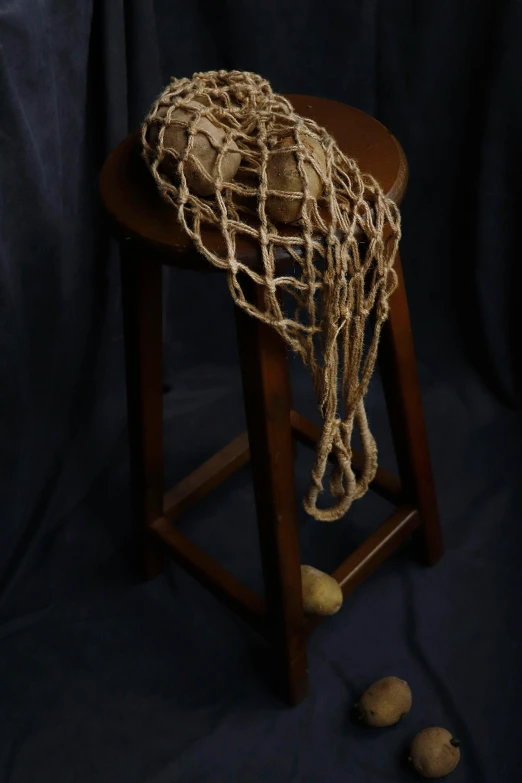 a wooden stool holding a rope covered object