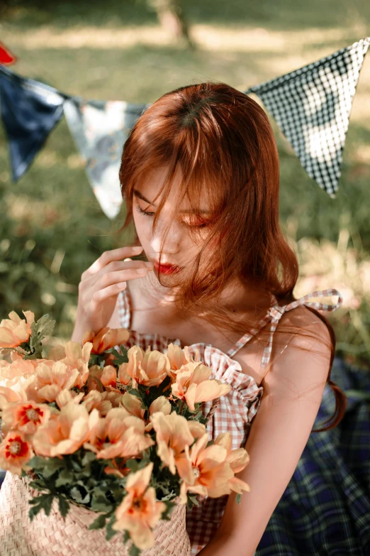 a woman sits in a field with some flowers