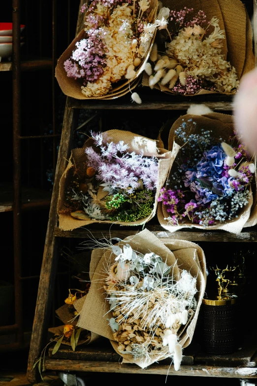 various different flowers sitting on old wooden boxes