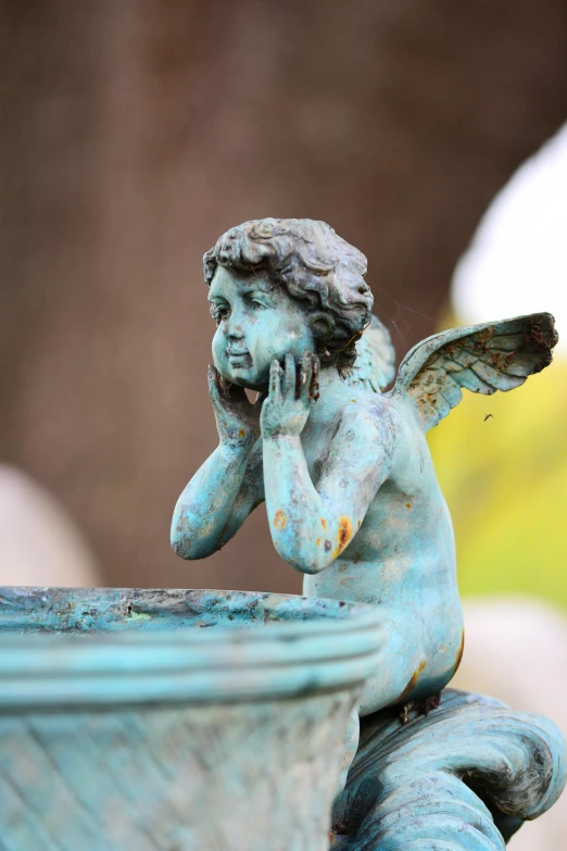 a blue angel figurine with its hand under it's ear