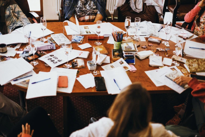 a large table full of papers and pens