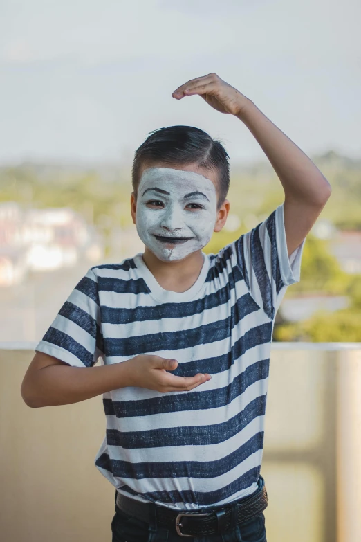 a little boy wearing striped t - shirt and painted face