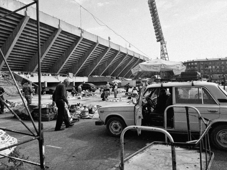 a small van sits near other cars and construction workers