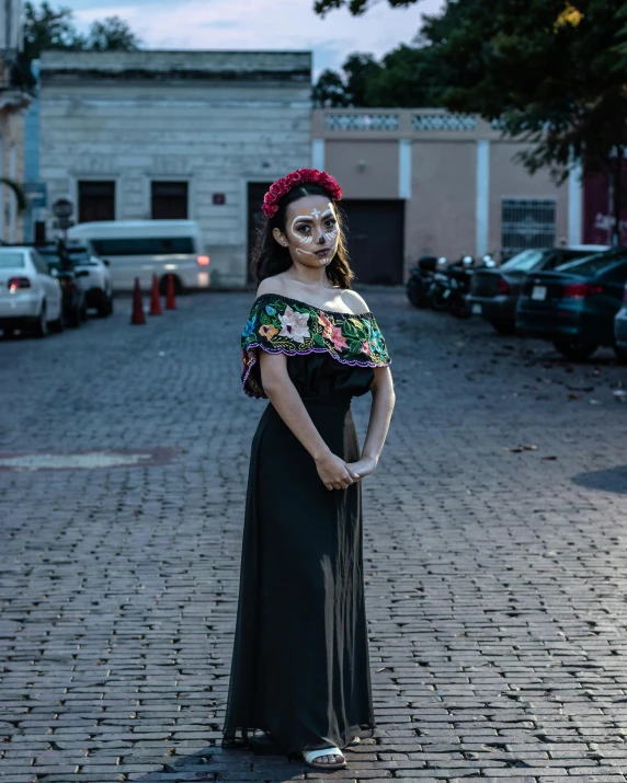 a woman in mexican dress poses with her head tilted