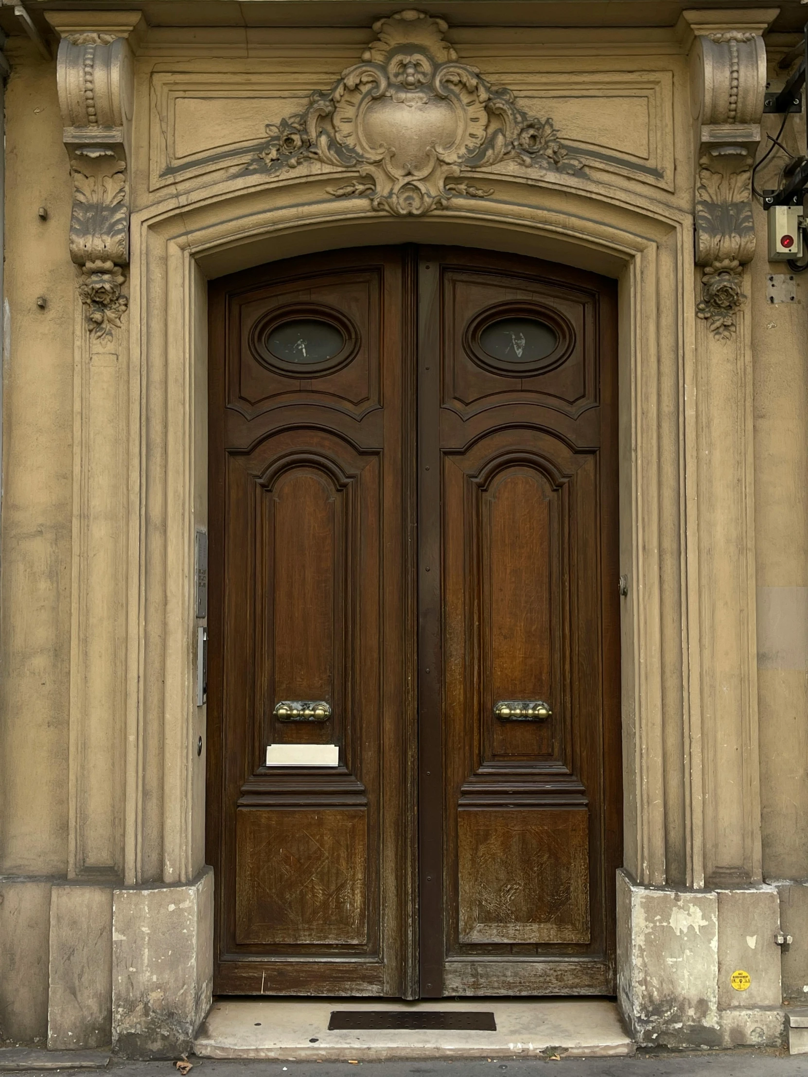 a couple of brown wooden doors are on a building