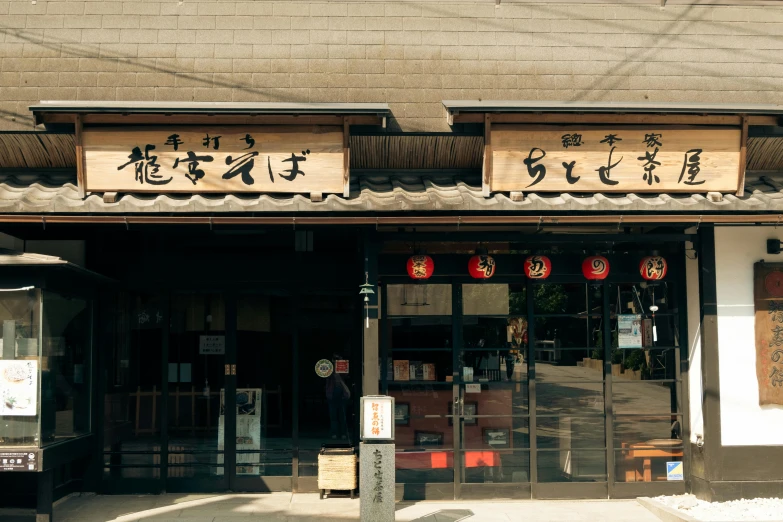 a store in the middle of a street with oriental calligraphy on it